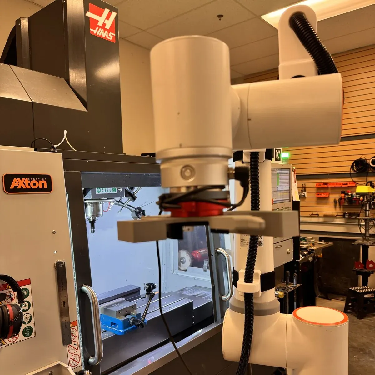 Collaborative robot with a parallel gripper positioned at the door of a Haas VF-2
