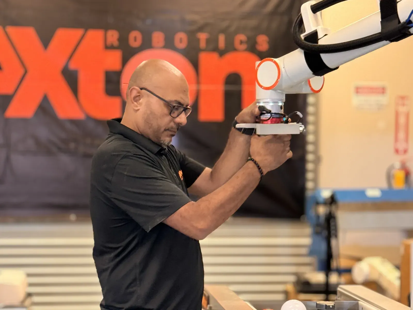 Michael Nessim hand-guiding a cobot arm to teach it a position in the Axton Robotics lab