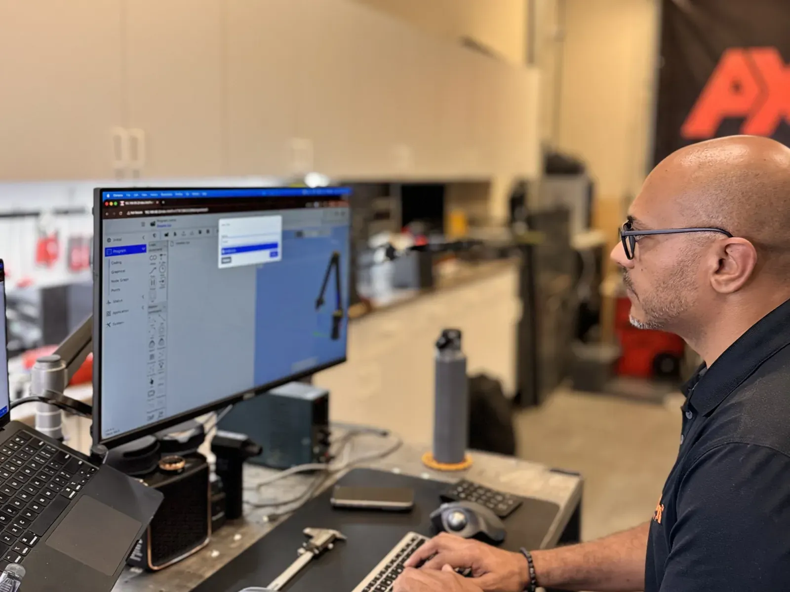Michael Nessim testing the Axton Robotics machine tending software on a computer