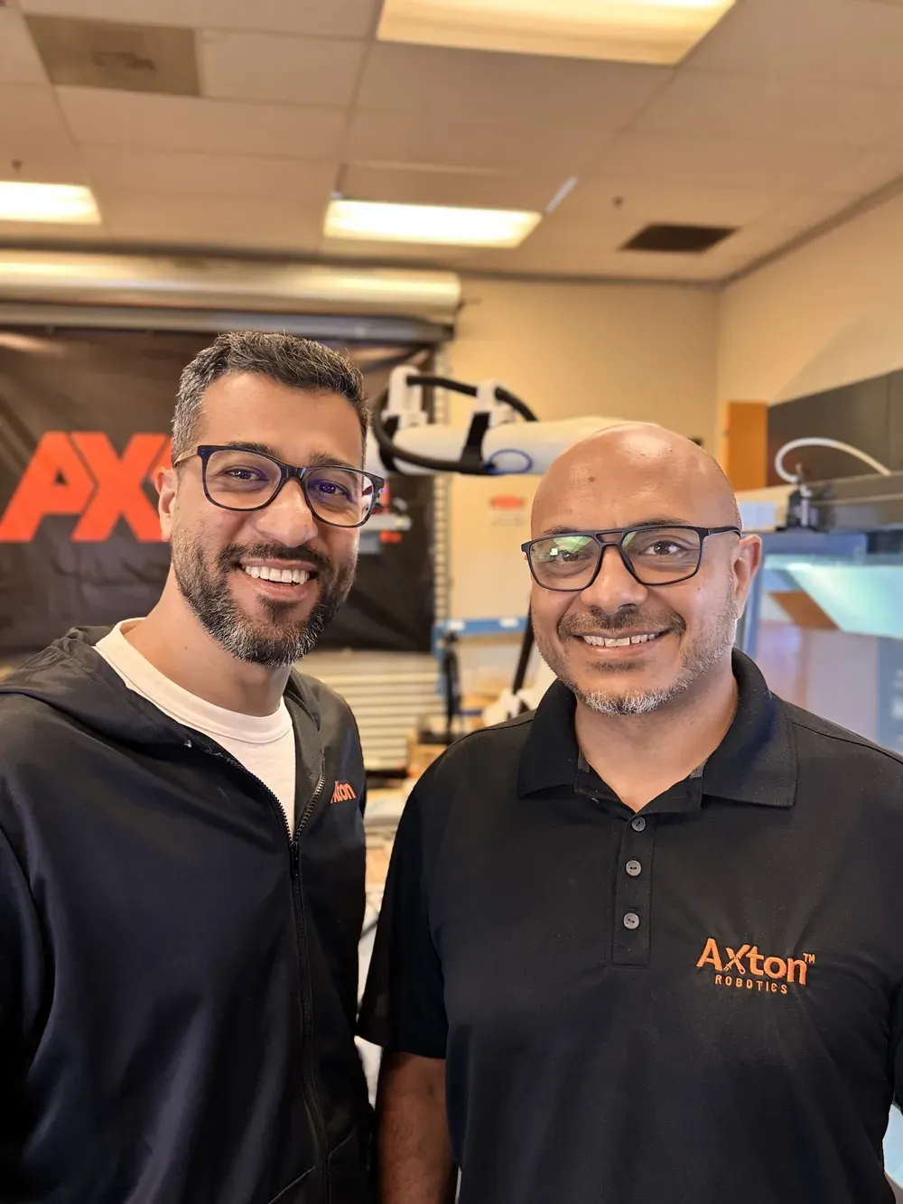 Axton Robotics co-founders Malak Mitch and Michael Nessim smiling in the Axton Robotics lab