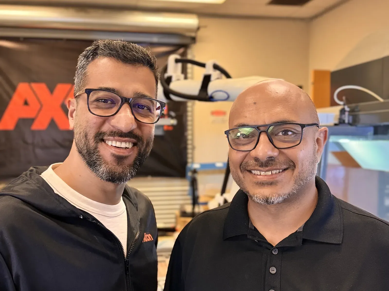 Axton Robotics co-founders Malak Mitch and Michael Nessim smiling in the Axton Robotics lab